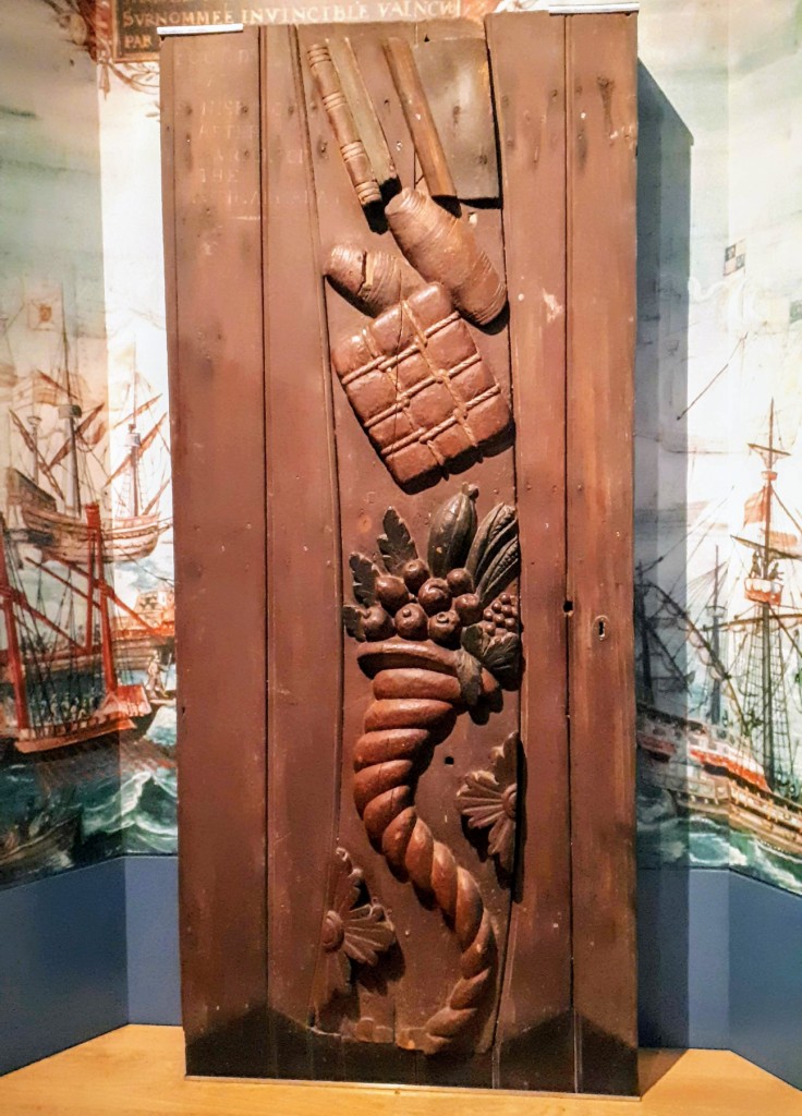Door featuring a carved cornucopia in the "Water" section of the "Riches of Clare" exhibit at the Clare County Museum. Reputed to have washed ashore due west of Ennis at Spanish Point (!), following the sinking of an Armada ship in 1588.