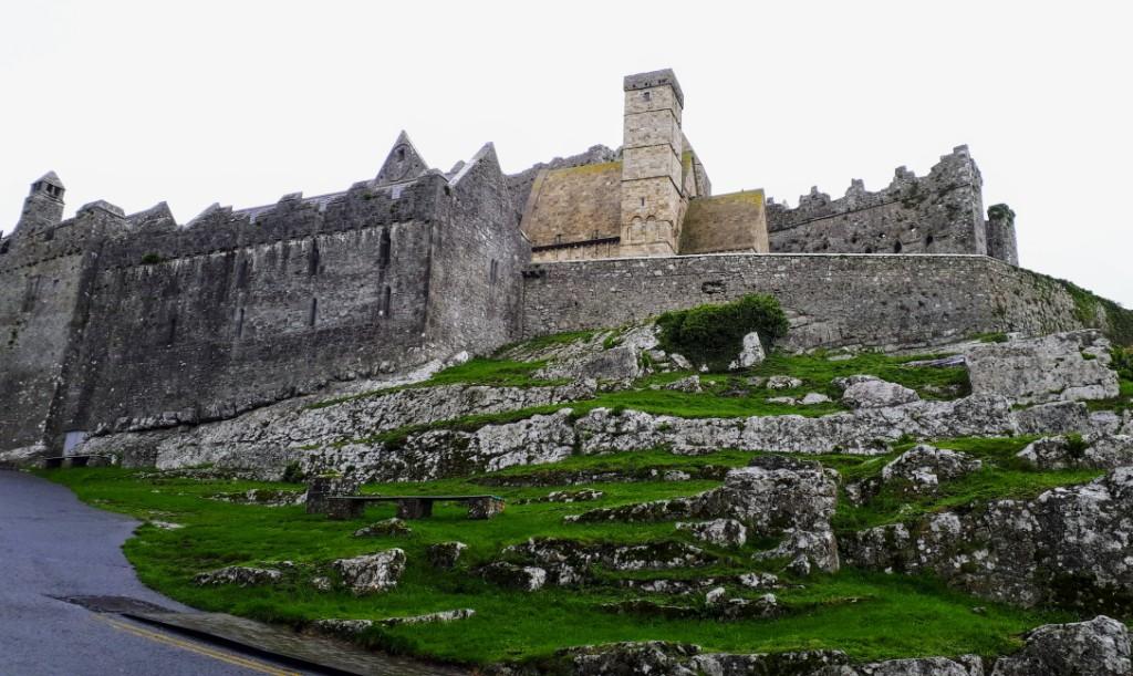 Walking uphill towards the entrance of the Rock of Cashel. One of the earliest buildings is the 1134 Romanesque Cormac's Chapel, at top centre, made of sandstone.